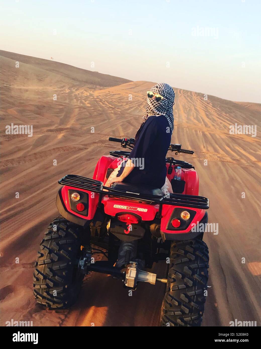 Dubai Desert, donna su di una moto quad facendo un tour al tramonto. Foto Stock