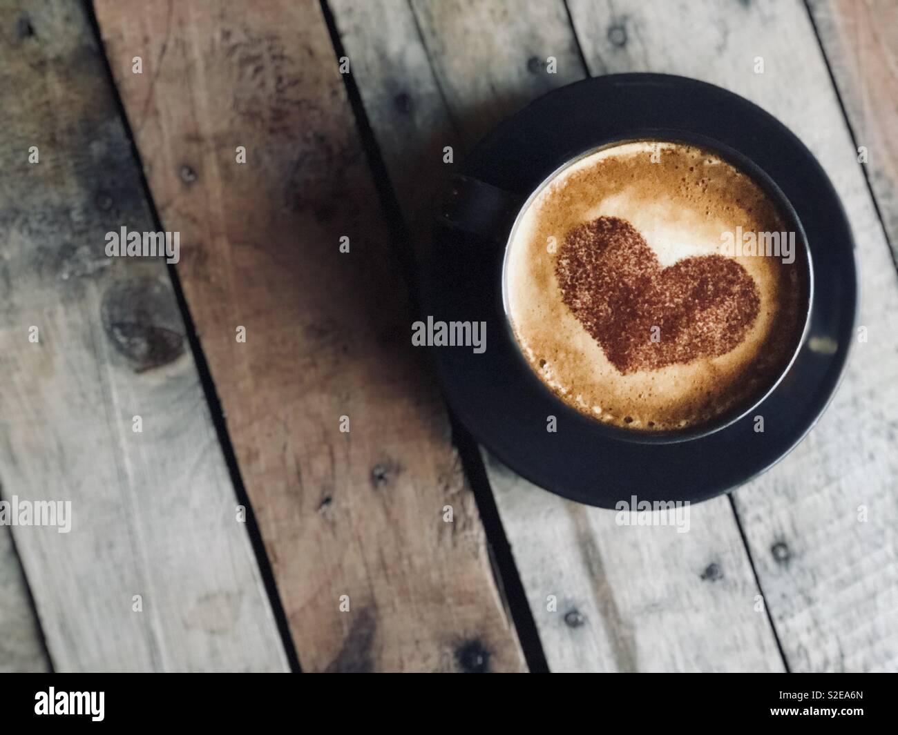 Caffè flatlay con cuore di cioccolato Foto Stock