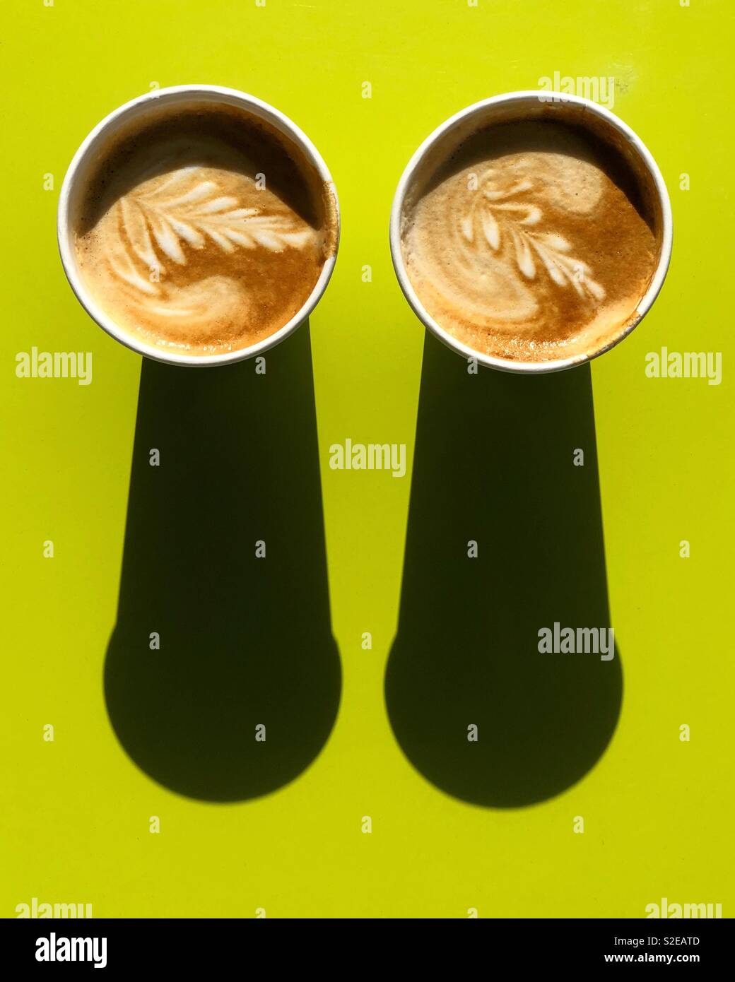 Due cappuccini con ombre sul tavolo verde - Immagine stock catturata con smartphone