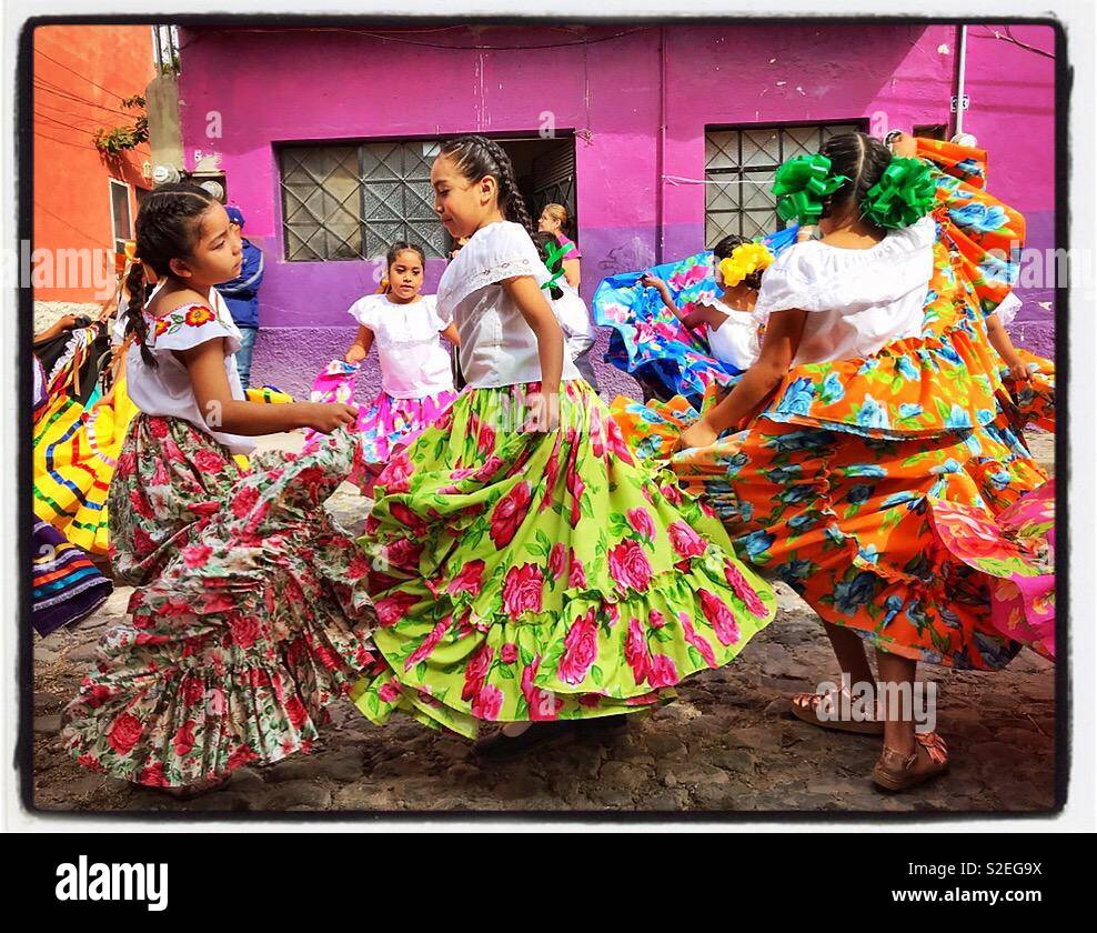 Le ragazze in colorate gonne di vorticazione dance su strade a ciottoli durante una rivoluzione parata del giorno in Messico. Foto Stock