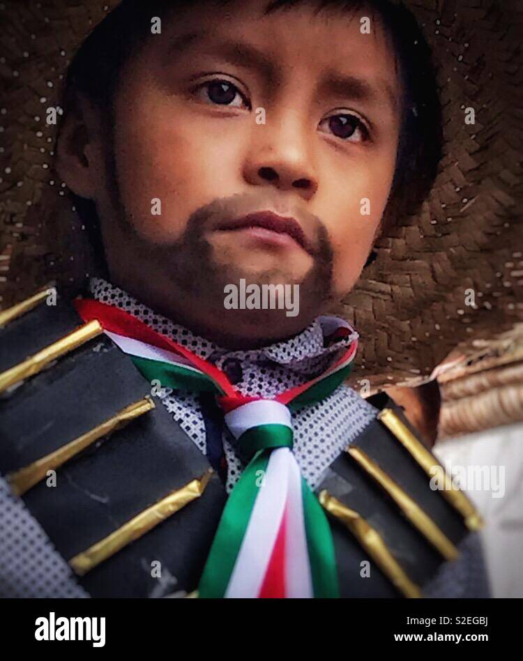 Un giovane ragazzo con un dipinto su i baffi e barba è vestito come un rivoluzionario mentre egli partecipa al Día de la Revolución sfilata in Messico. Foto Stock