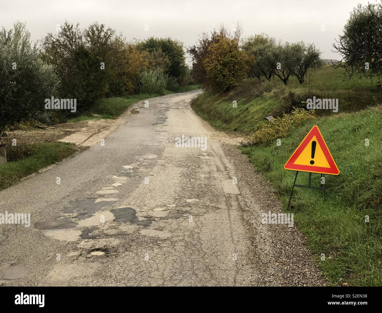 Strada irregolare con un cartello stradale Foto Stock