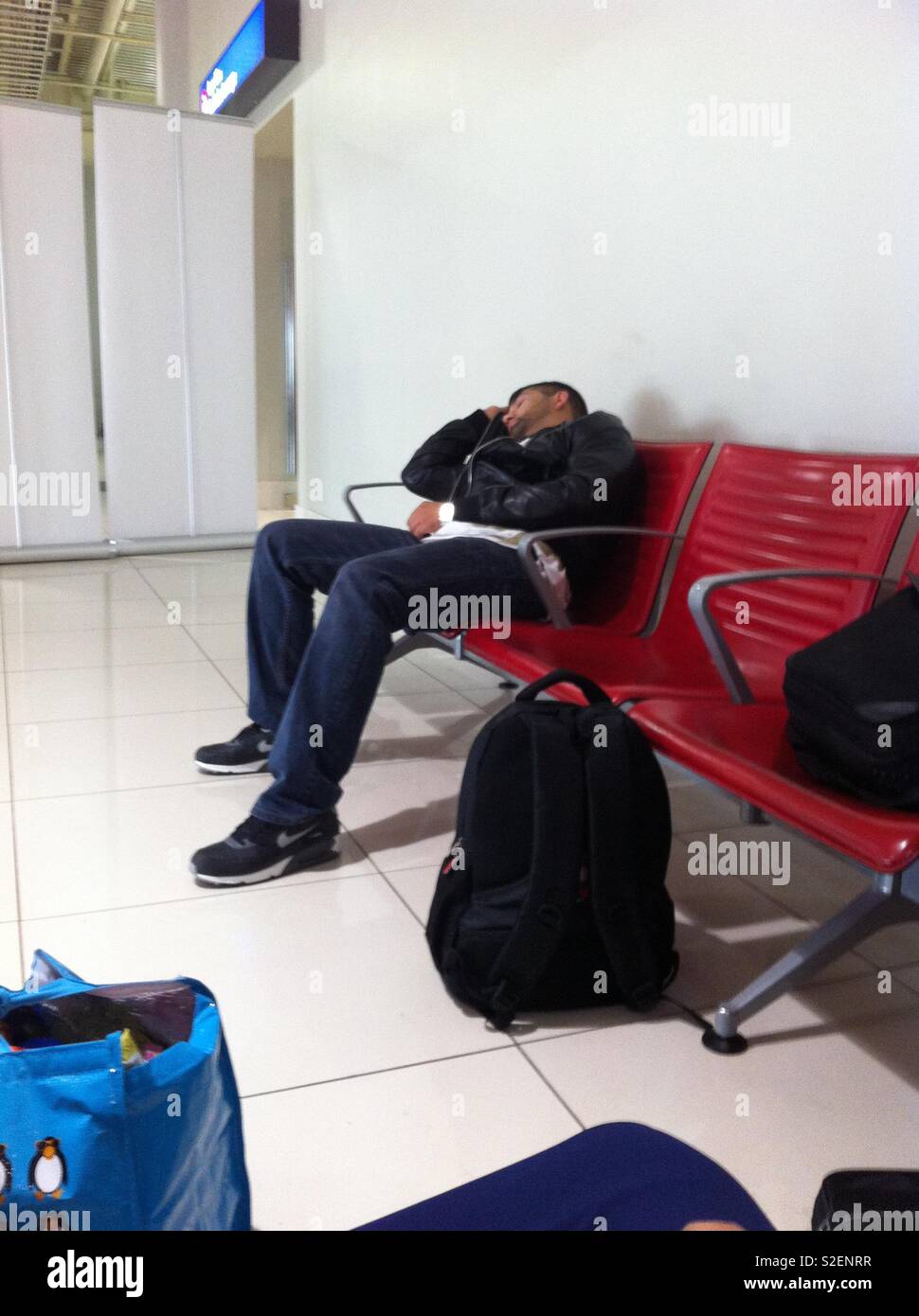 Uomo dorme in aeroporto Foto Stock