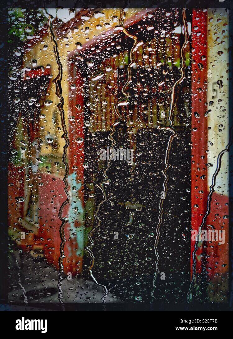 Un variopinto edificio esterno è fotografato attraverso una finestra di auto in un giorno di pioggia in Ajijic, Messico. Foto Stock