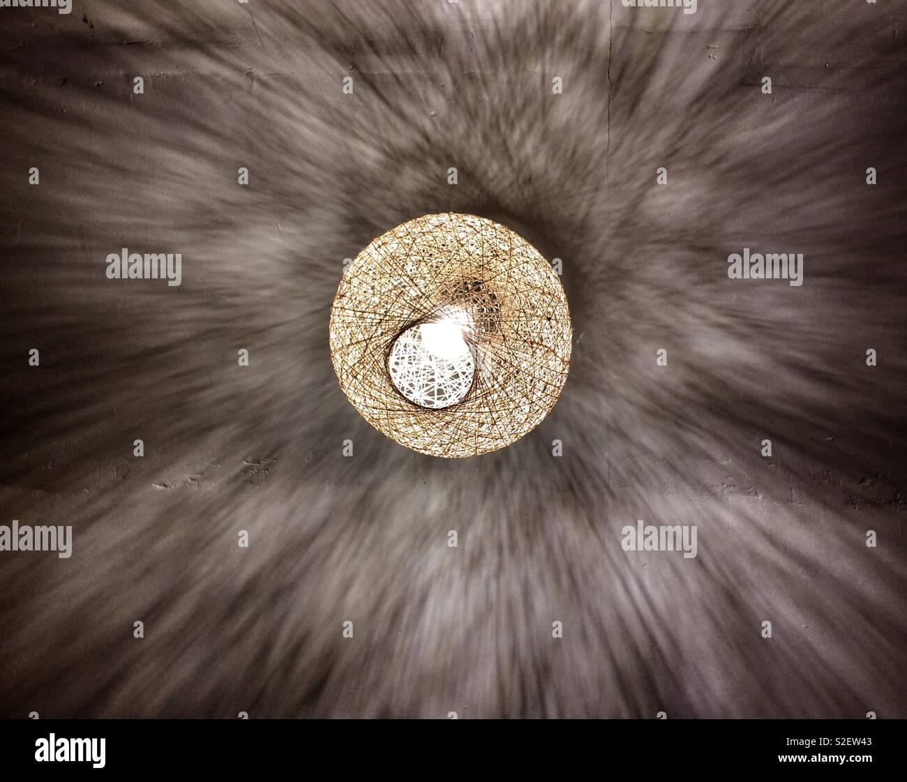 Modelli di luce e ombra sono espressi su di un soffitto da un paralume in tessuto Foto Stock