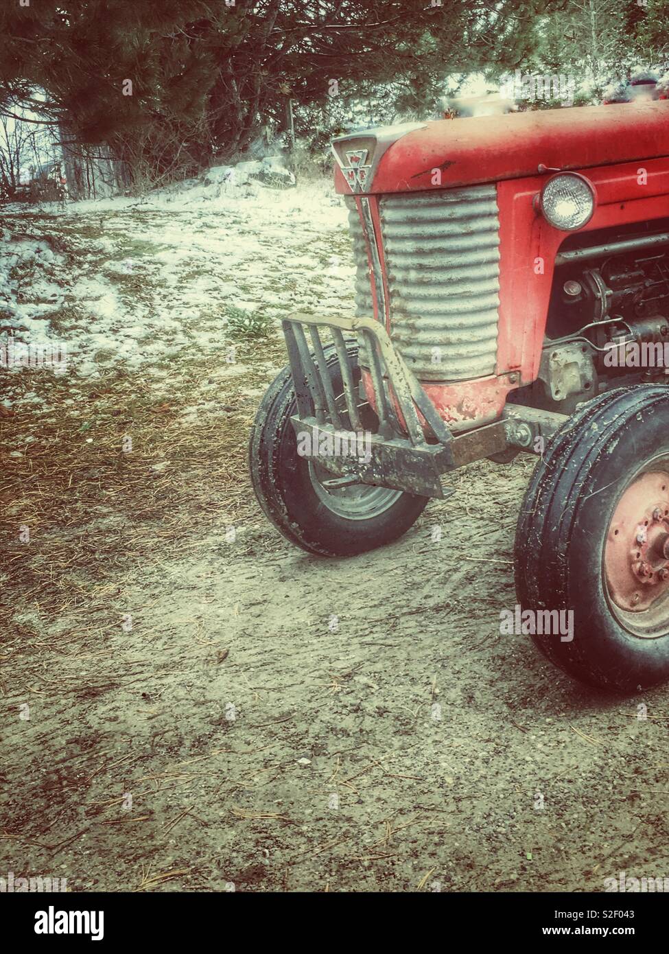 Trattore rosso, rosso vecchio trattore agricolo impostato nel campo nevoso Foto Stock