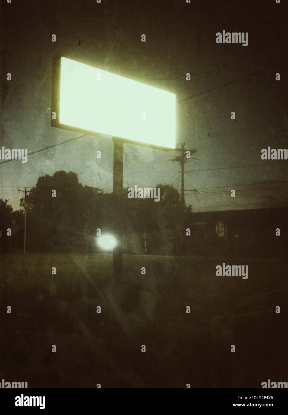 Monocromatica foto grunge di vuoto, eerie illuminato segno negozio al crepuscolo Foto Stock