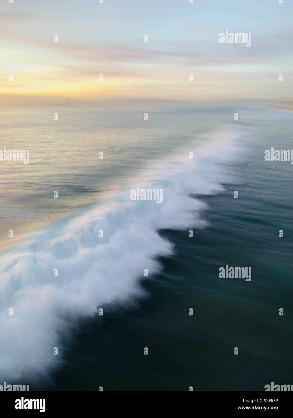 Una velocità di sfocatura di un'onda rompere al tramonto. Manhattan Beach, California USA. Foto Stock