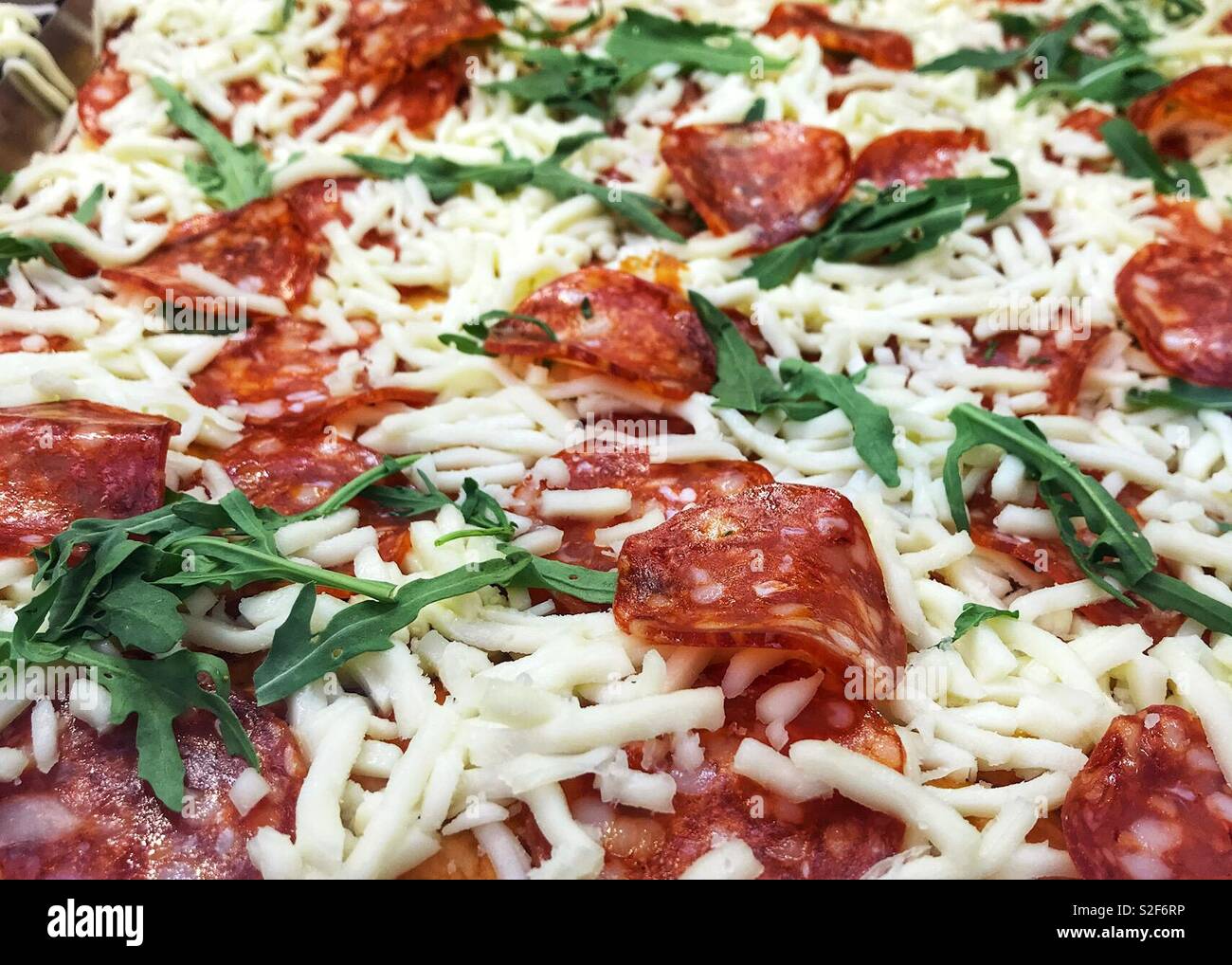 Salsiccia per pizza pizza con fresche foglie di rucola Foto Stock