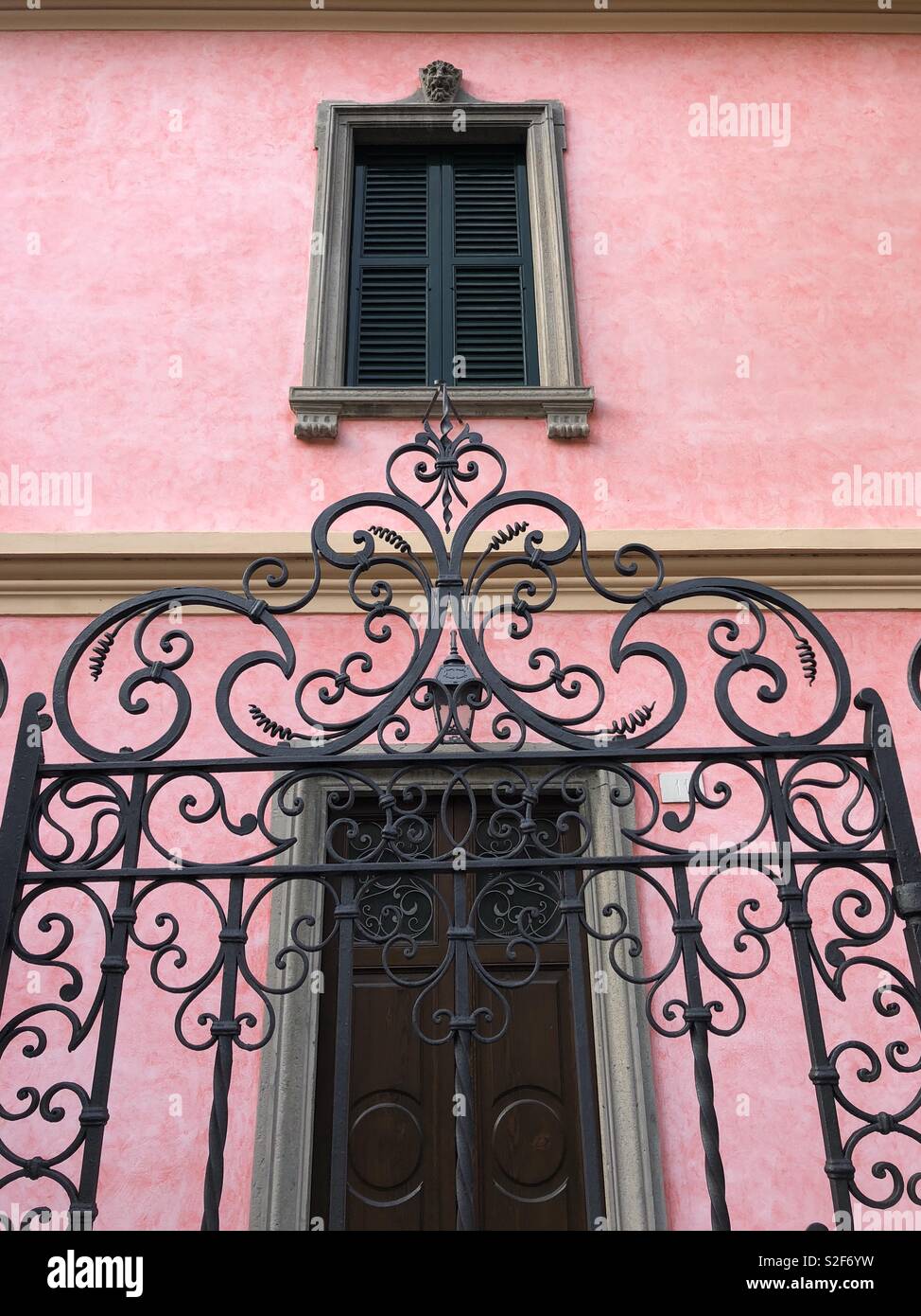 Heartshaped gate nella parte anteriore della perfetta casa rosa con otturatori Foto Stock