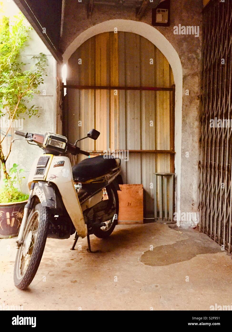 Vecchio ciclomotore sotto il portico di un tradizionale edificio su Beach Street in Georgetown, Penang, Malaysia - Immagine stock catturata con smartphone