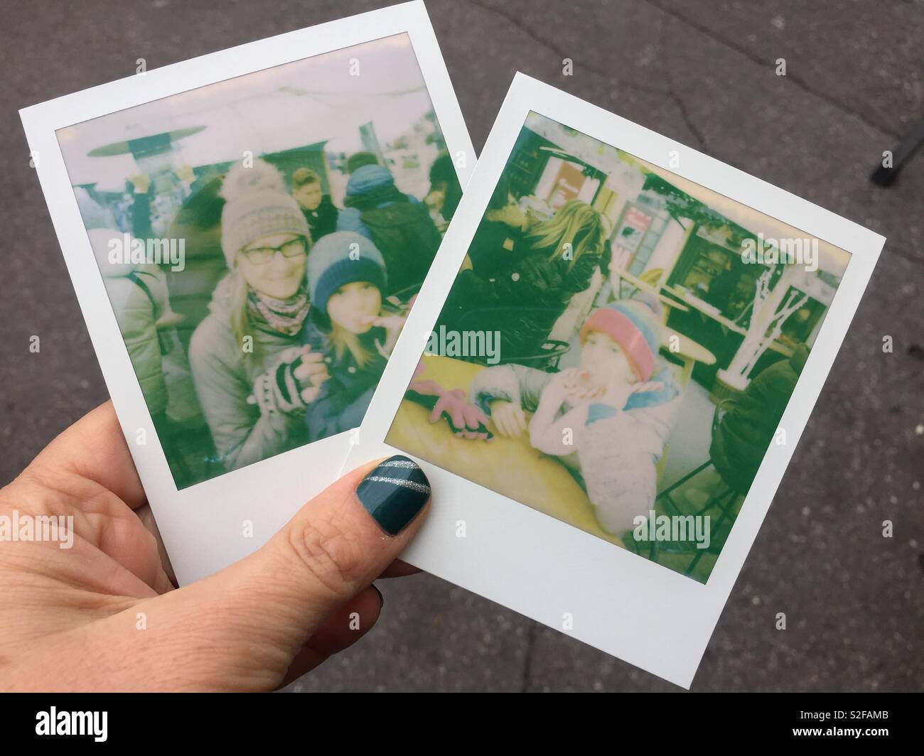 Donna di mano che regge due polaroid di donna e bambini Foto stock - Alamy