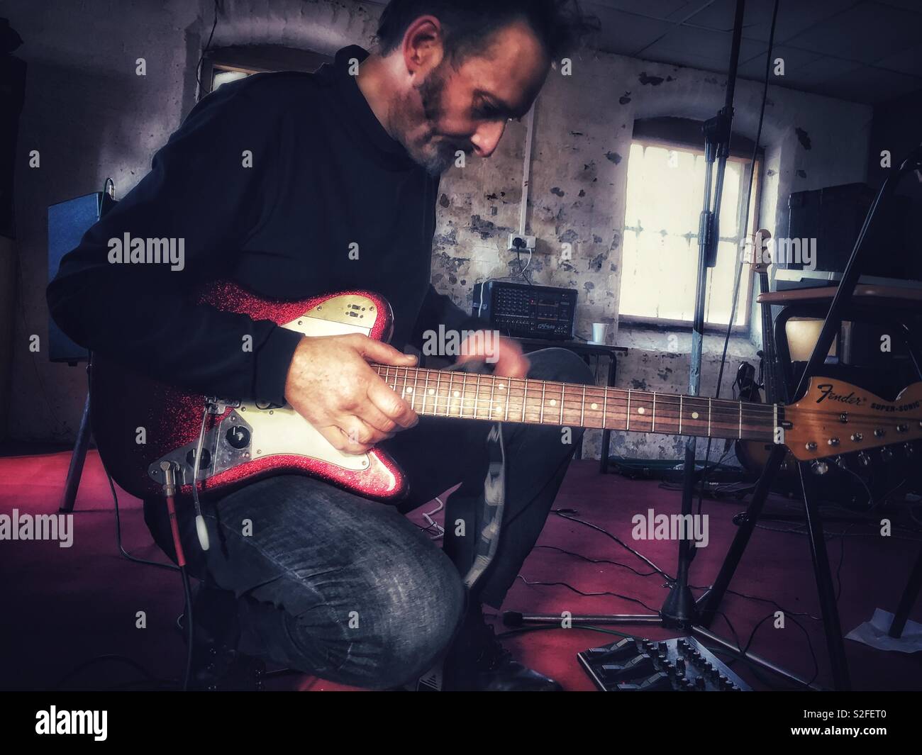 Riflessivo uomo anziano con chitarra elettrica Foto Stock