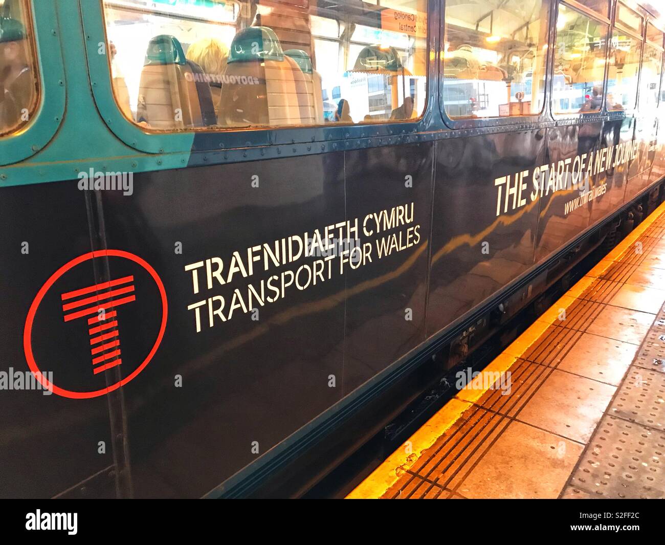 Diesel treno dei pendolari in corrispondenza di una piattaforma per la Stazione Centrale di Cardiff che porta il nuovo "Trasporto per il Galles" sviluppato di branding per il Galles e bordi franchising, che è iniziata nel mese di ottobre 2018. Foto Stock