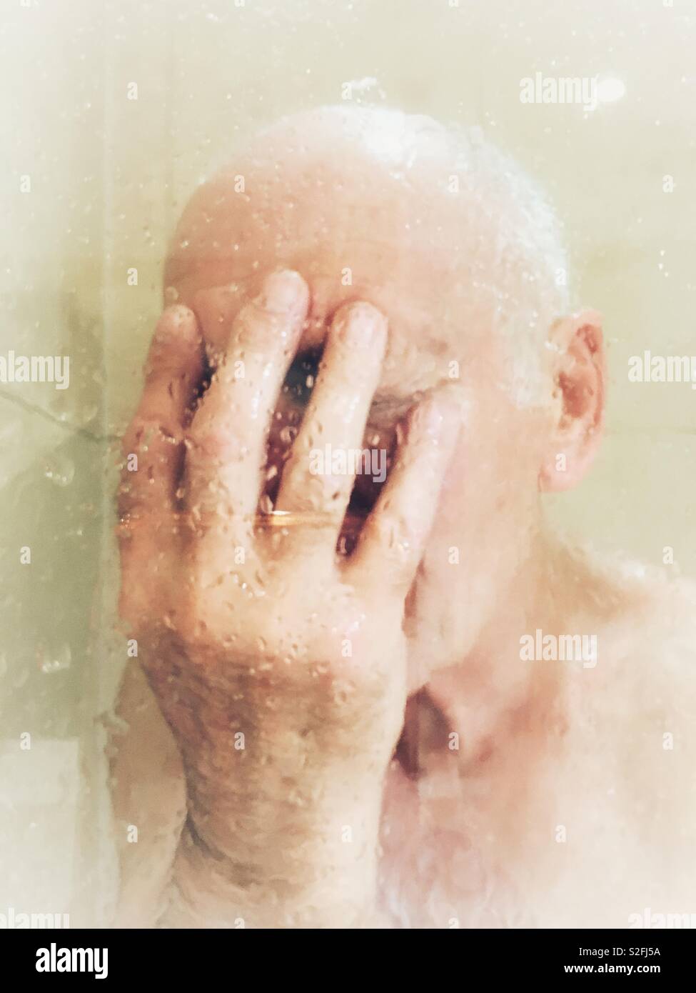Uomo che ricopre la faccia nella doccia - Immagine stock catturata con smartphone