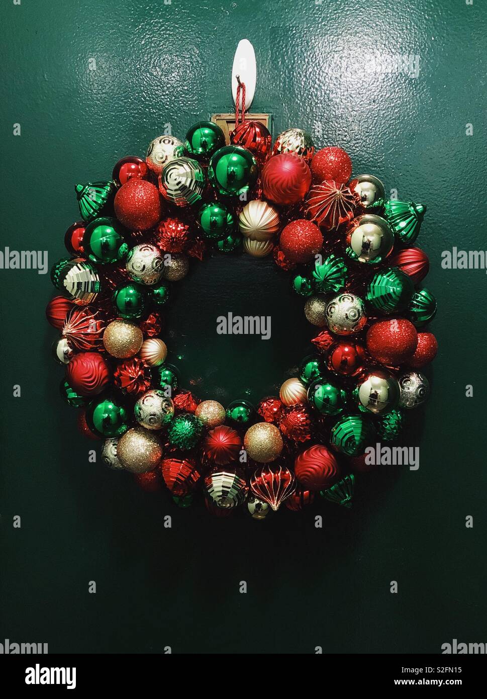 Ornato ghirlanda di Natale sulla porta verde. Foto Stock