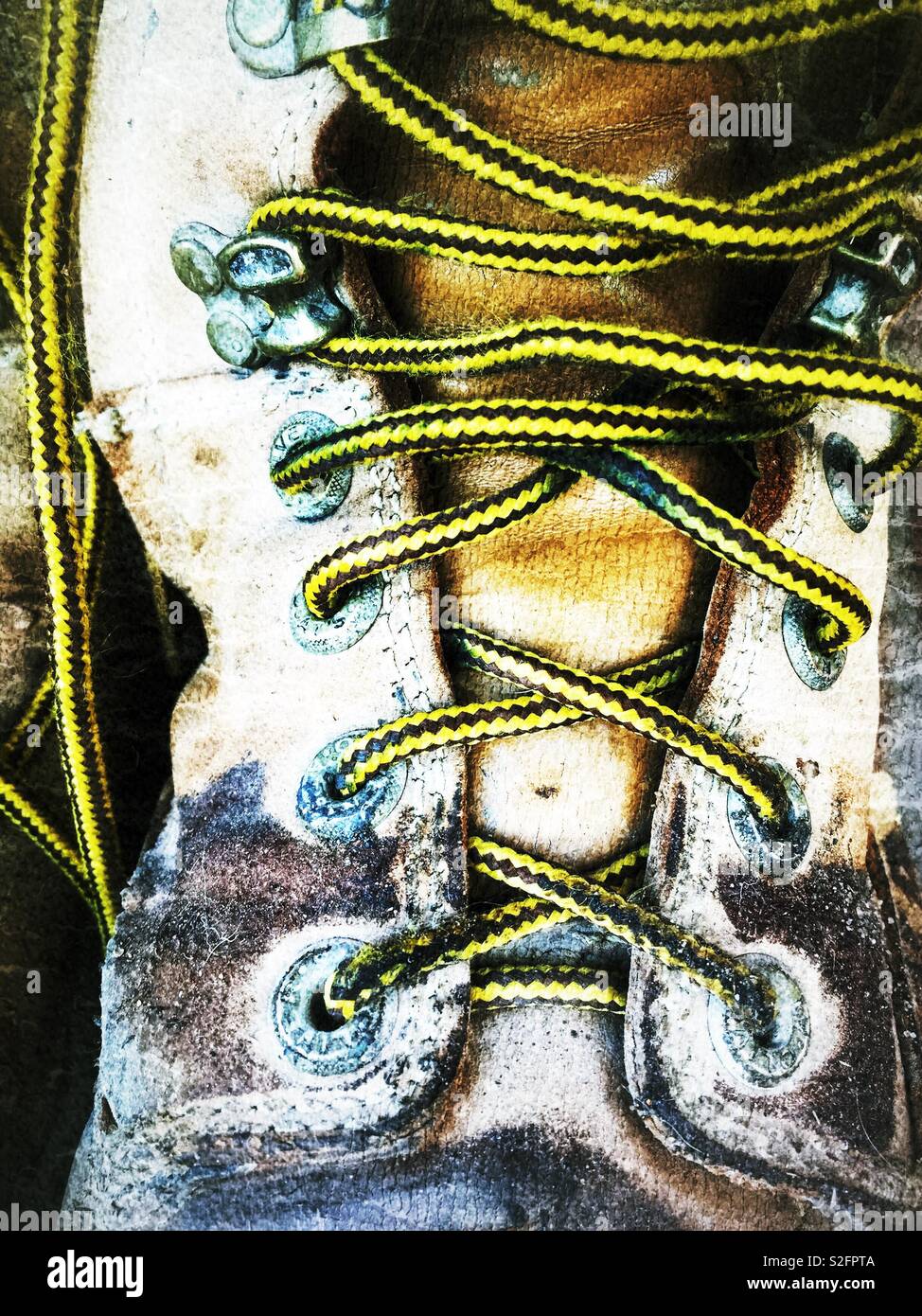 Vecchia pelle usurati escursionismo boot e lacci. Primo piano della weathered scarpe con lacci di colore giallo Foto Stock