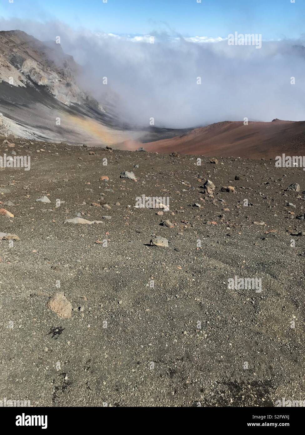 Nuvole e piccolo arcobaleno nel cratere Haleakalā Foto Stock