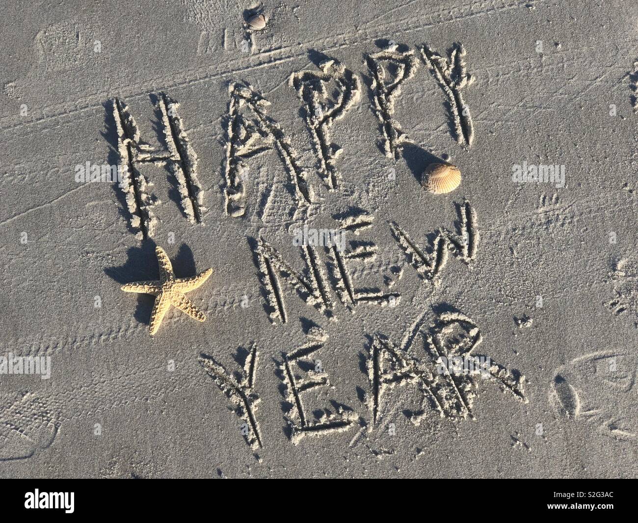 Felice Anno Nuovo scritto nella sabbia al Ponte Vedra Beach, Florida il giorno di Capodanno - Immagine stock catturata con smartphone