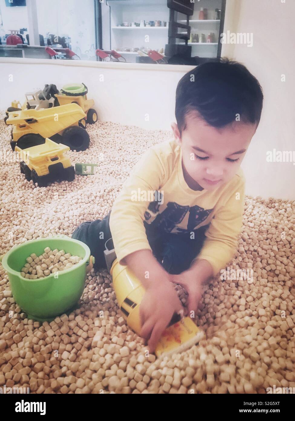 Un bambino di 3 anni ragazzo indonesiano in un bambino sito in costruzione room giocare. Foto Stock