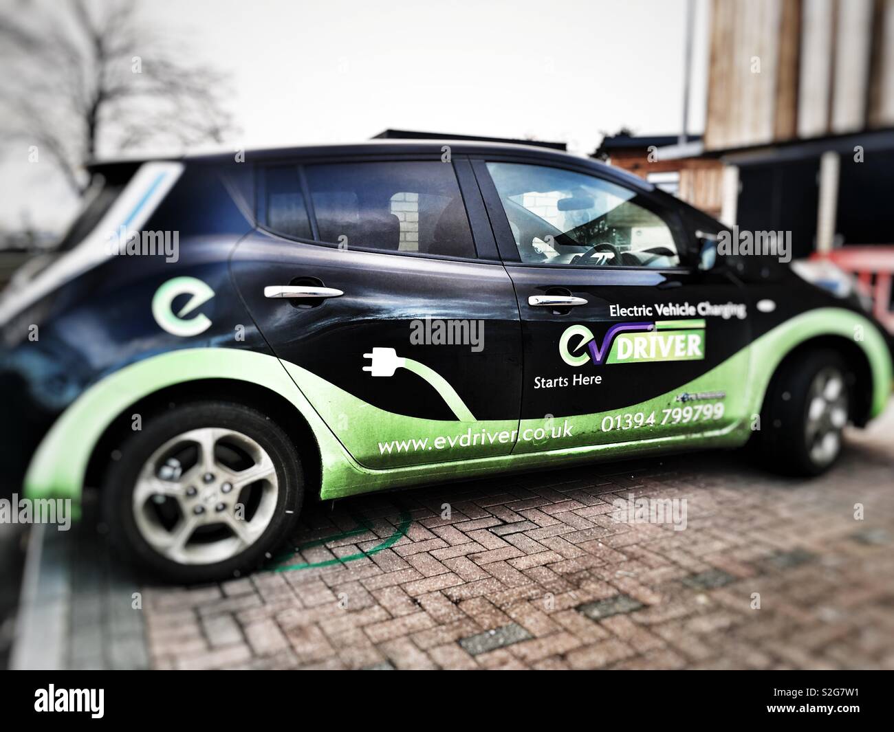 Il veicolo elettrico la carica - Immagine stock catturata con smartphone