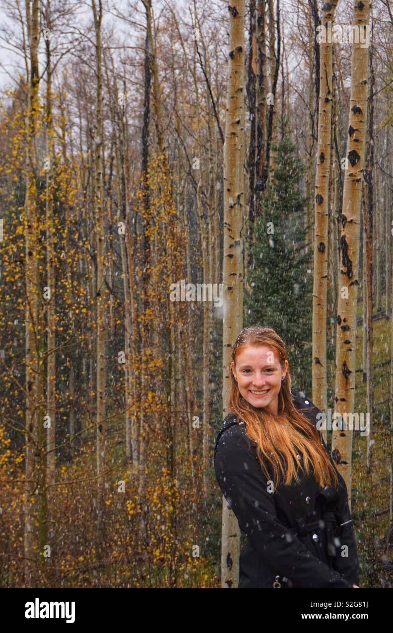 Redheaded donna in Aspen Forest tempesta di neve Foto Stock