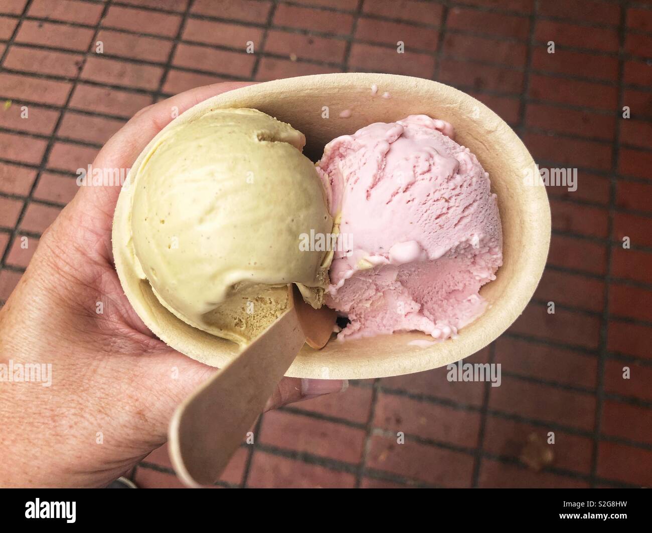 Mano che tiene la coppa di gelato Foto Stock