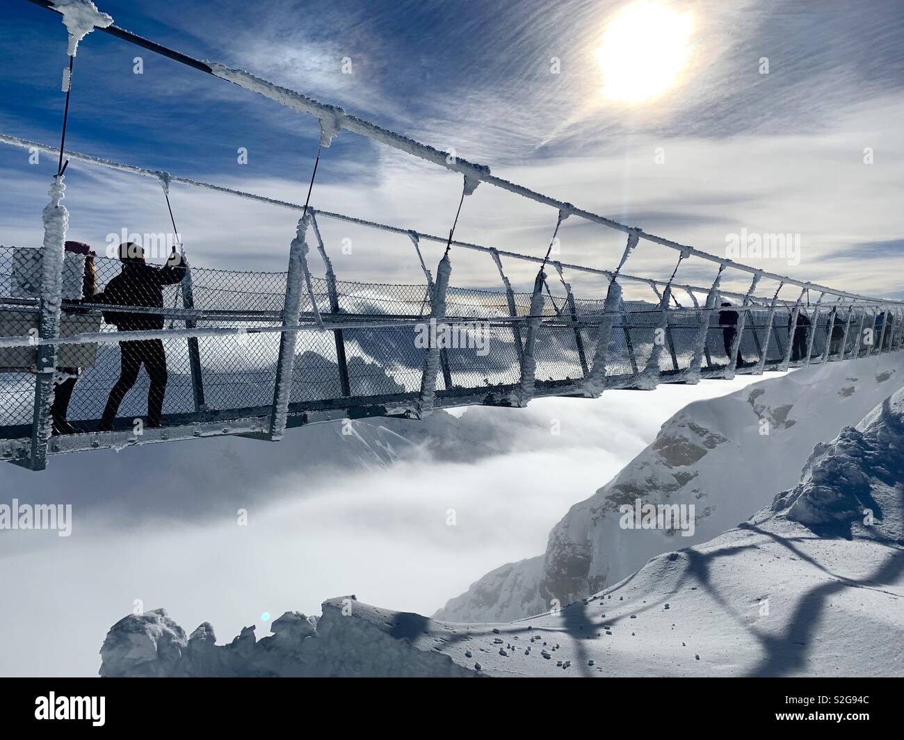 Tourist prende una foto sul ponte sospeso più alto d'Europa. Il ponte è a Monte Titlis al di sopra di Engelberg, Svizzera. Foto Stock