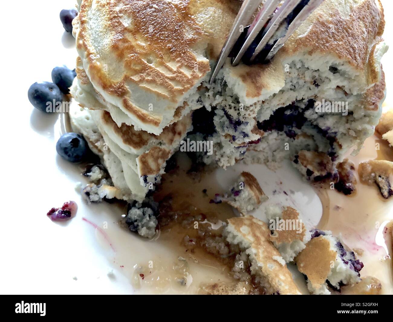 Forcella il taglio in una pila di pancake di mirtilli - Immagine stock catturata con smartphone