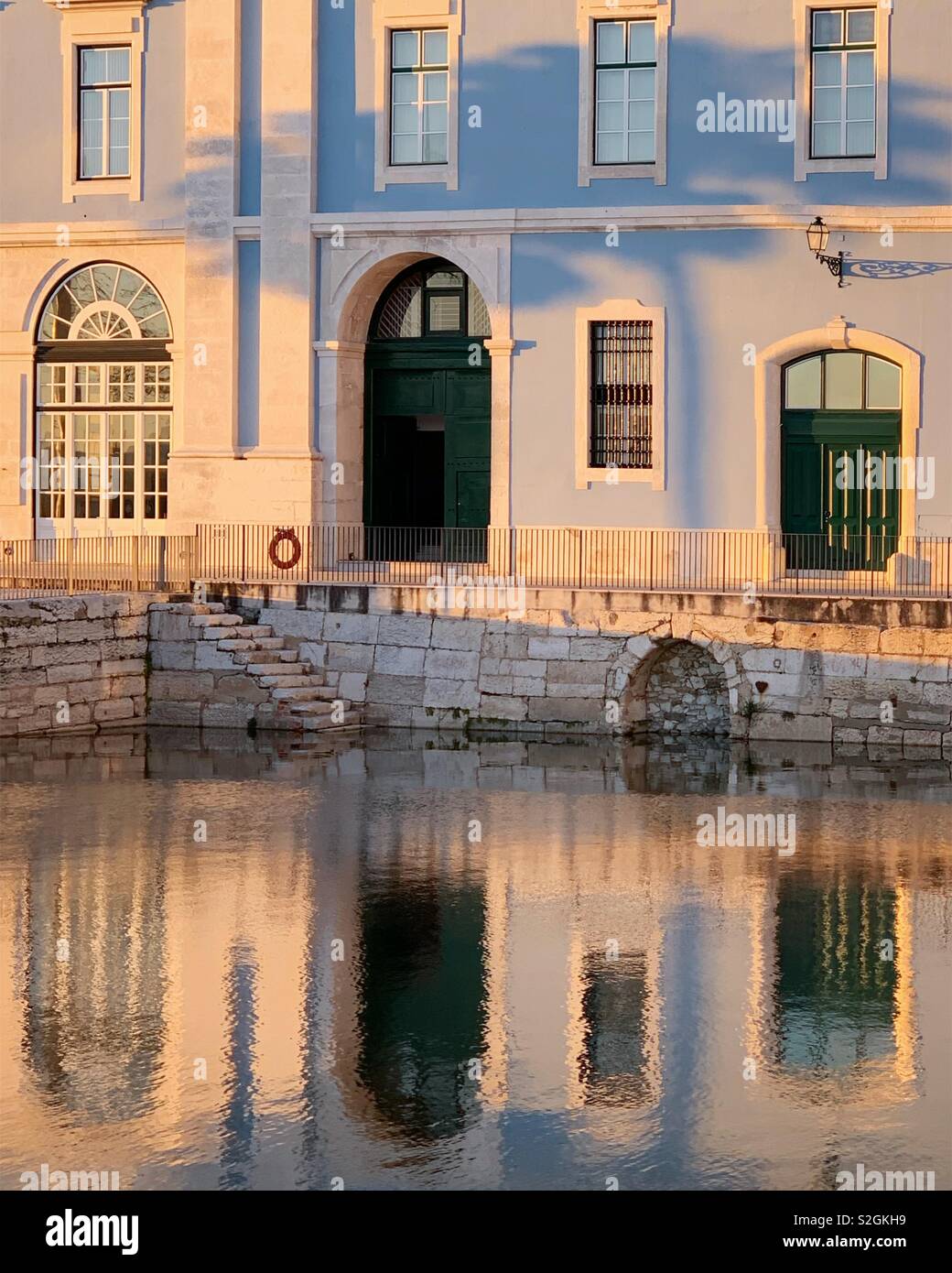 Riflessioni di architettura lungo il fiume Tago a Lisbona Portogallo. Dicembre 2019 e l'ombra del palm tree sulla costruzione Foto Stock
