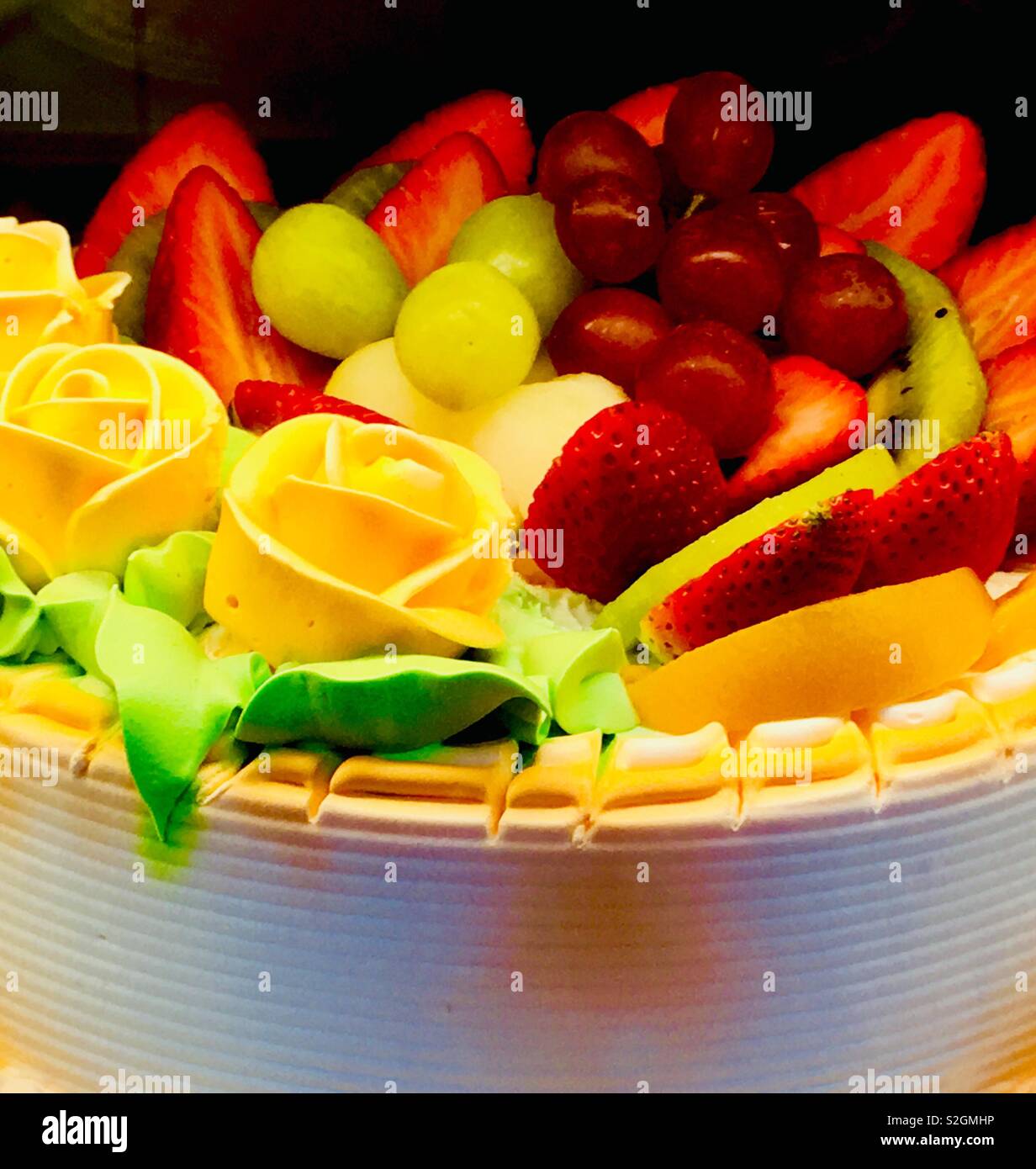 Decorativo cinese torta con rose gialla e frutta fresca. - Immagine stock catturata con smartphone