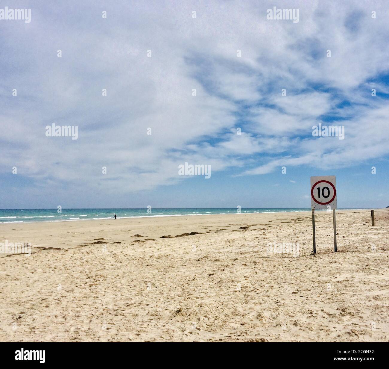Un segno di velocità su una quasi deserta spiaggia Foto Stock