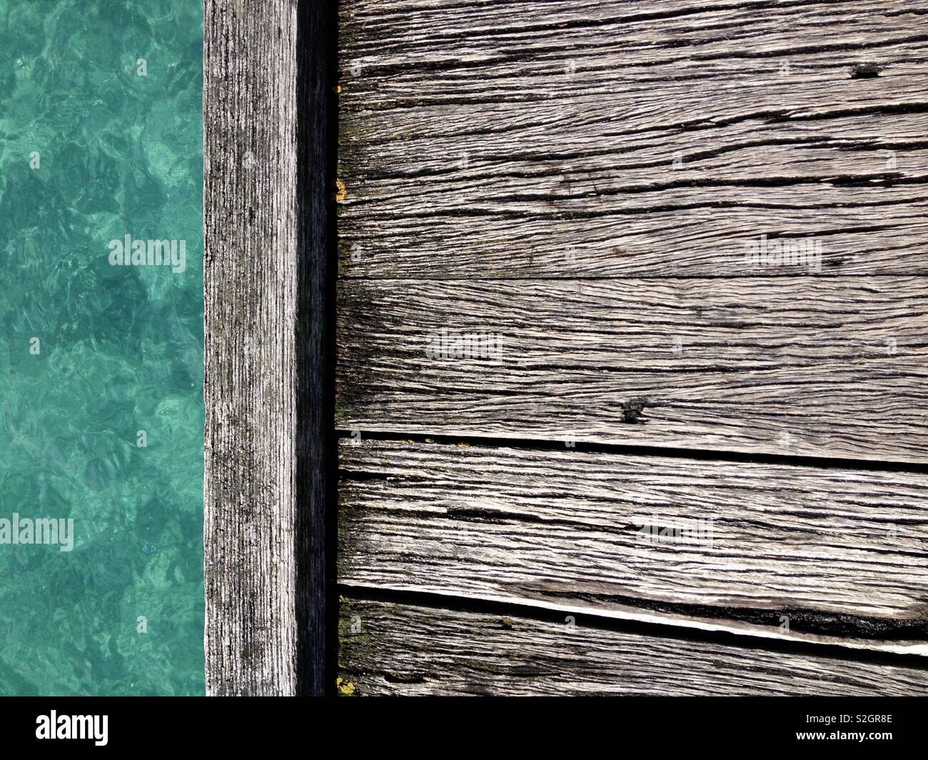 Vecchio pontile in legno peir close up con chiara acqua del mare turchese in background Foto Stock