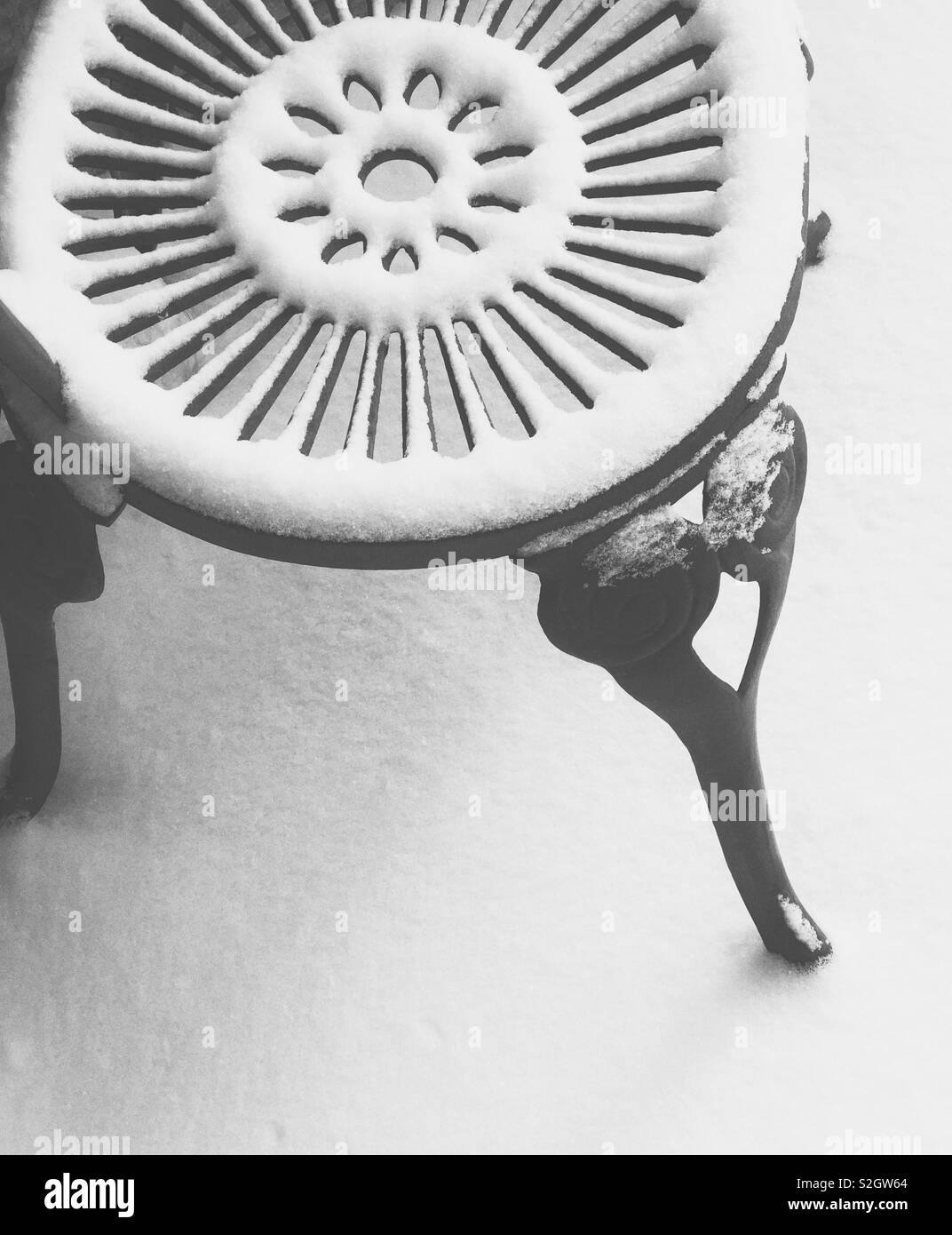 Neve fresca su uno stile antico del ferro battuto sedia con interessante percorso circolare Foto Stock
