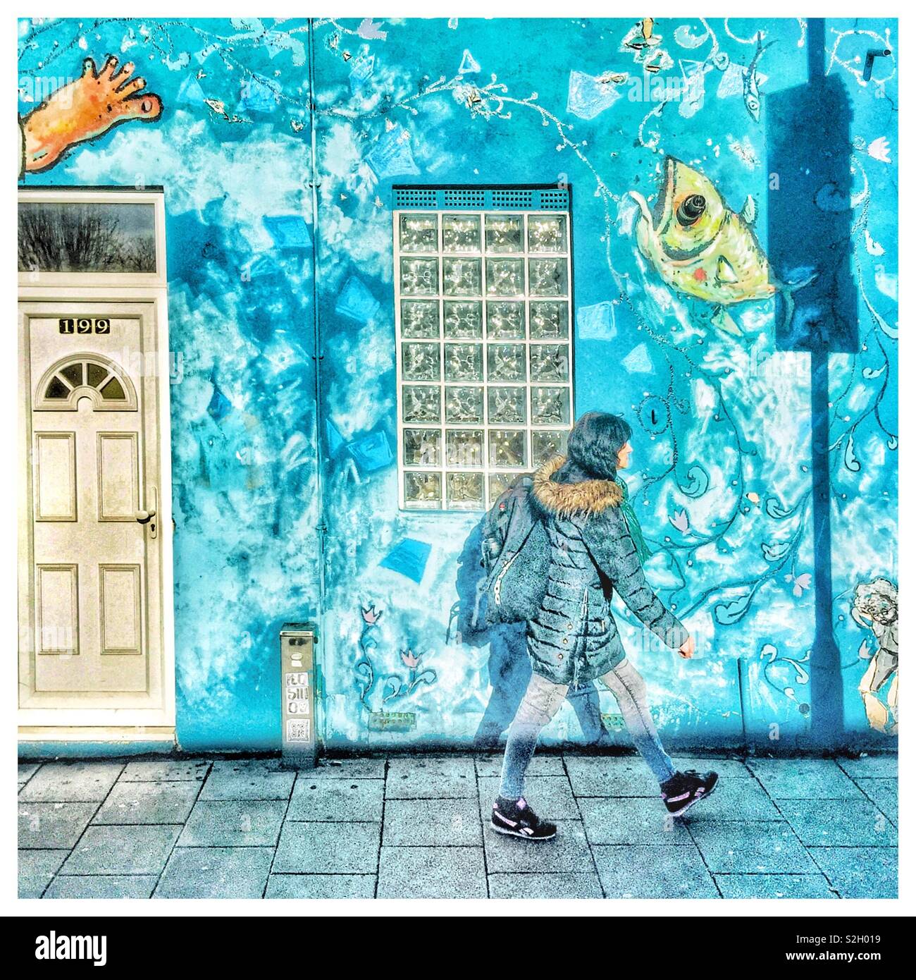 Una donna che cammina passato arte di strada. - Immagine stock catturata con smartphone