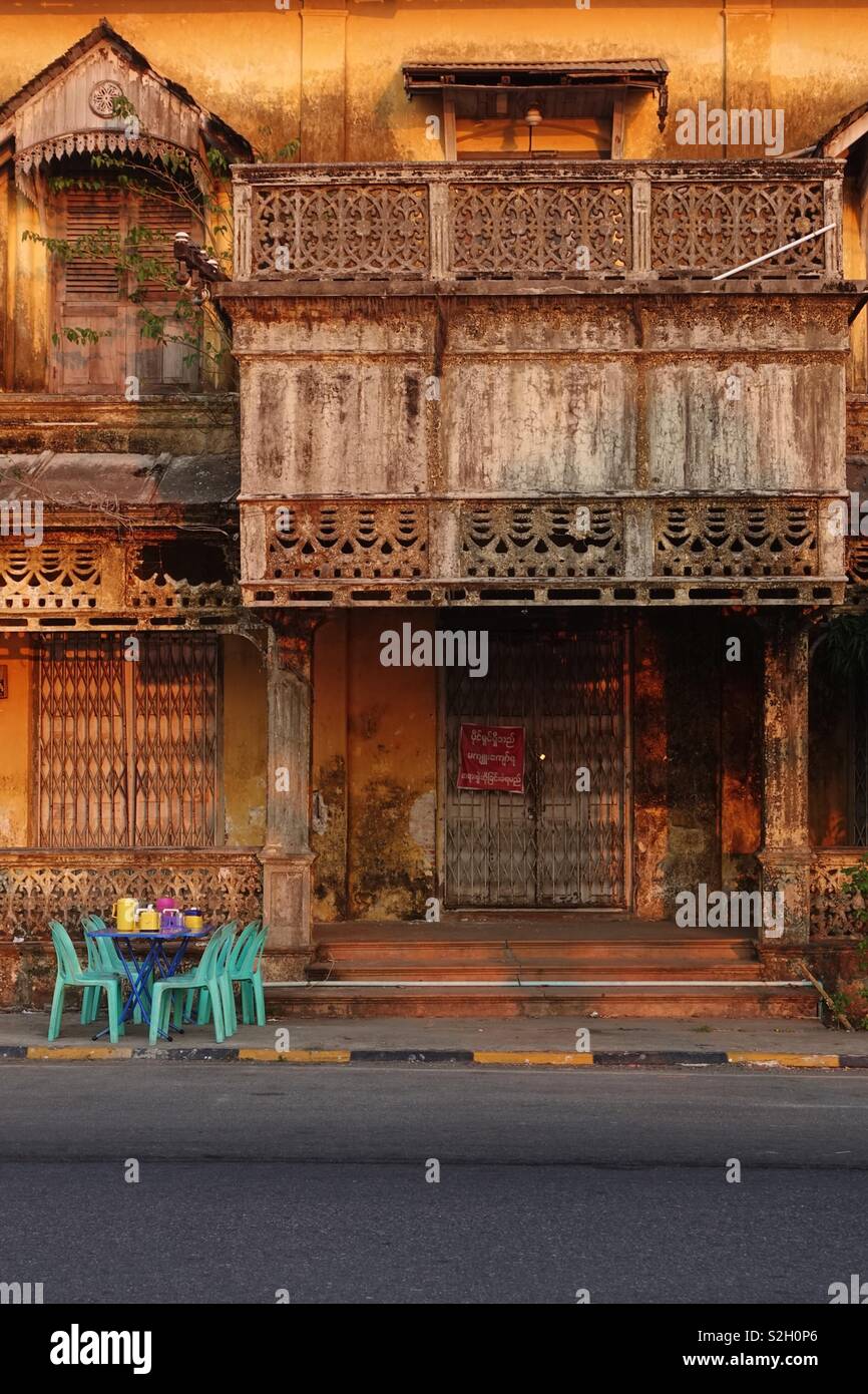 Vecchio, vintage, abbandonati e abbandonato la casa con sedie di plastica e la tabella nella parte anteriore. Trovato in MYANMAR Birmania Foto Stock