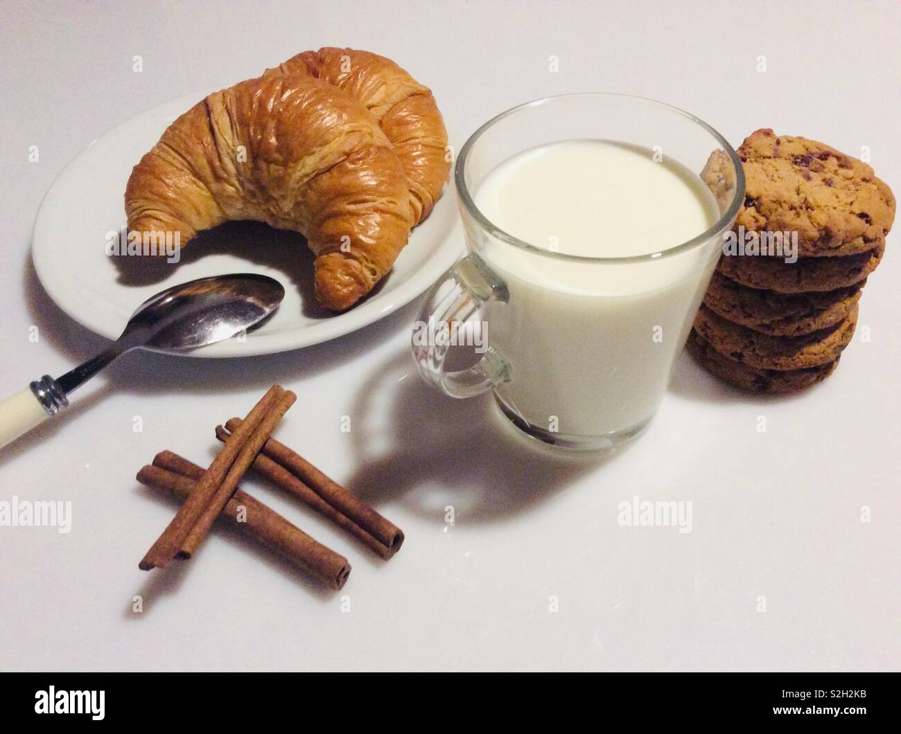 La prima colazione con croissant, fatti in casa a base di mirtillo palustre e biscotti al cioccolato e un bicchiere di latte Foto Stock