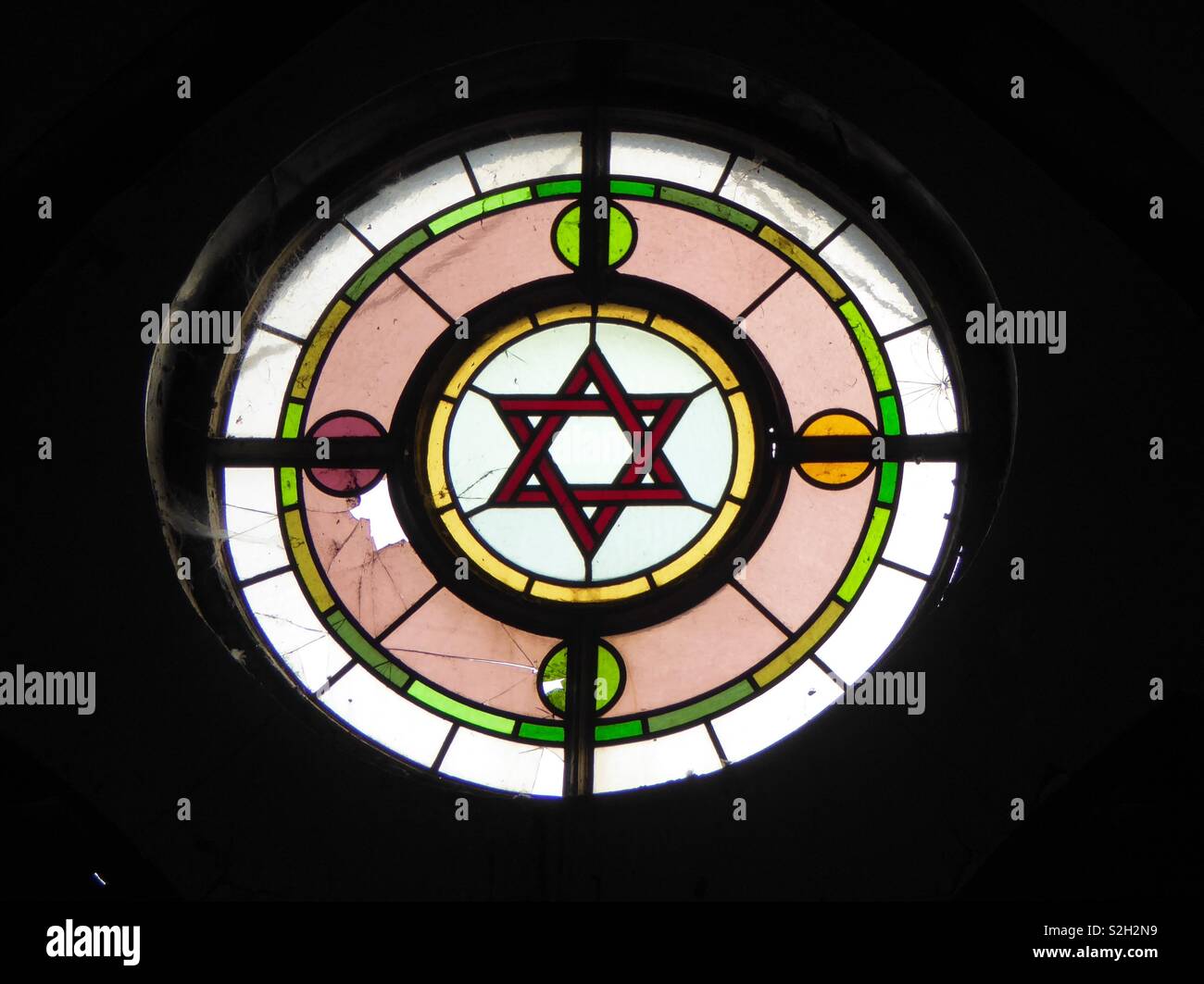 Roundel della bella ma decaduta vittoriana di vetro macchiato del delitto ex sinagoga di Merthyr Tydfil, nel Galles del Sud con una stella di Davide. - Immagine stock catturata con smartphone