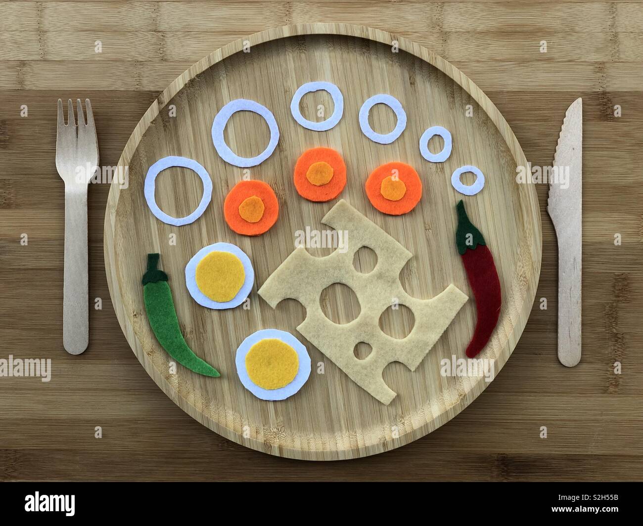 Un sano concetto di pasto con vestiti art design su un piatto di legno - Immagine stock catturata con smartphone