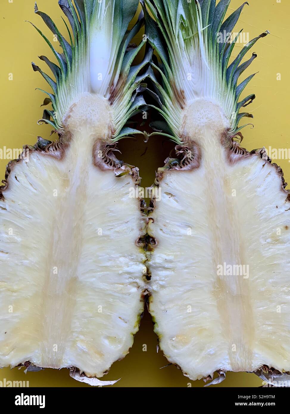 Un ananas tagliato in due metà mostrato affiancate dall'interno Foto Stock