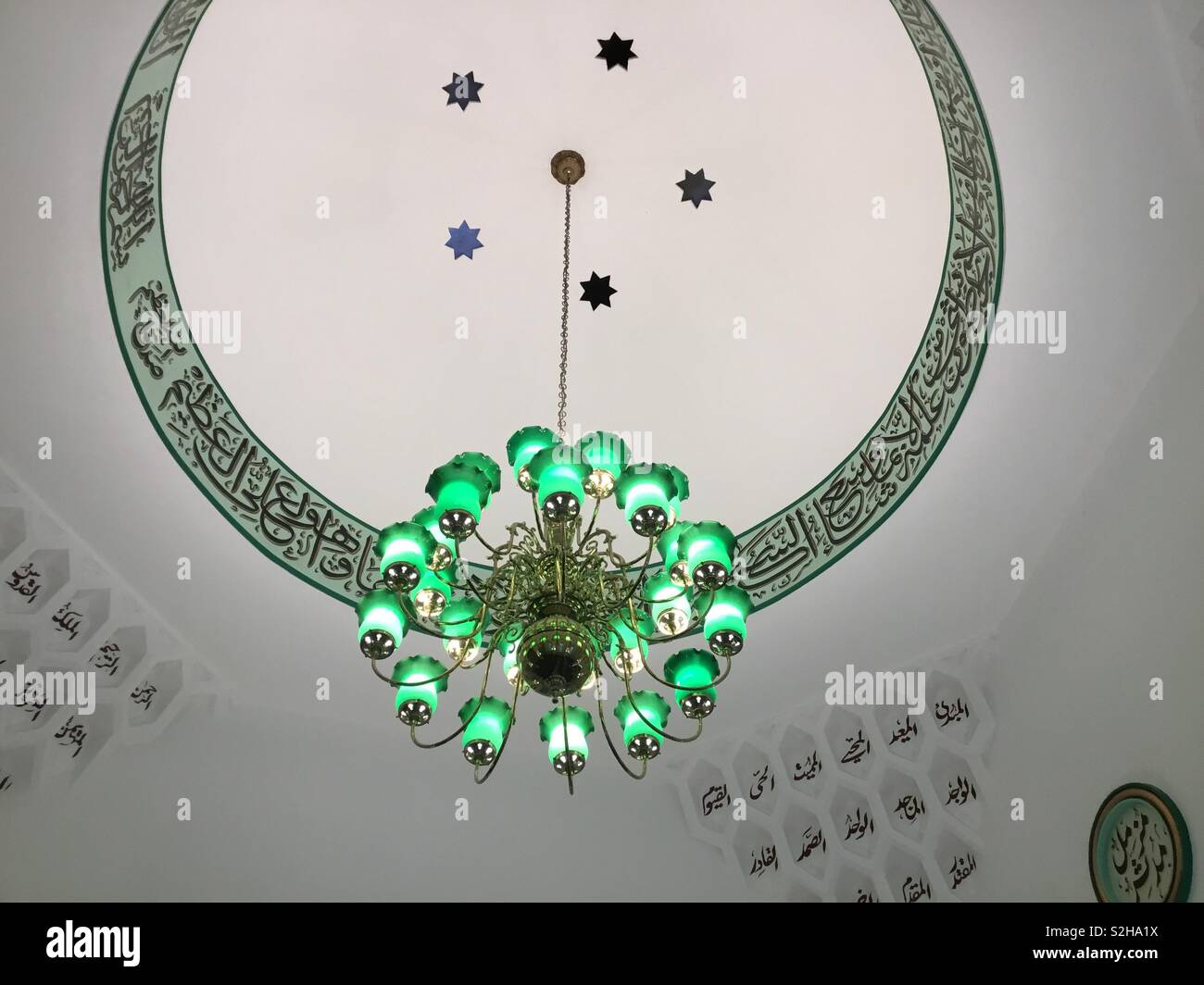 Bella scena interna della cupola a Woking moschea, Inghilterra del più antico costruito a tale scopo moschea con la calligrafia islamica e testi coranici e superbe lampada verde tonalità contrastanti con il decor di colore bianco. - Immagine stock catturata con smartphone