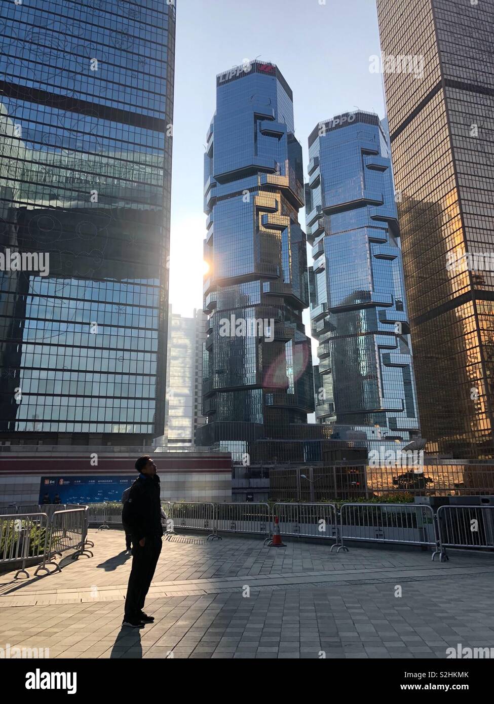 Un uomo in piedi di fronte ad un grattacielo,Hong Kong Foto Stock