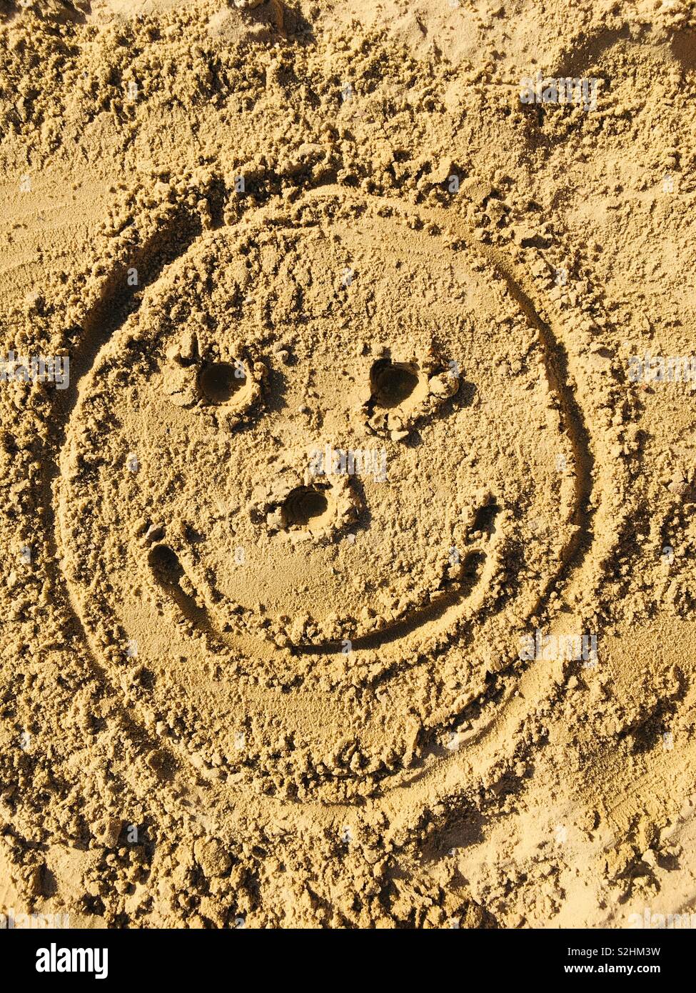 Smiley face in sabbia - Immagine stock catturata con smartphone