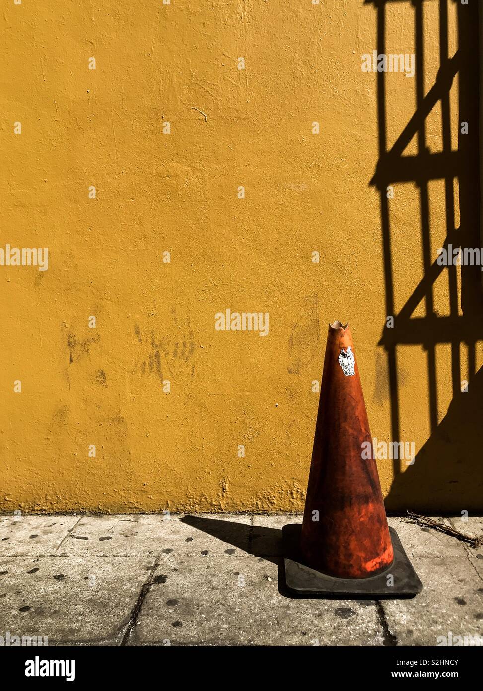 Coniche del. Lonely arancione contro il cono luminoso giallo parete in Oaxaca de Juarez, Oaxaca, Messico. 16 Febbraio 2019 - Immagine stock catturata con smartphone