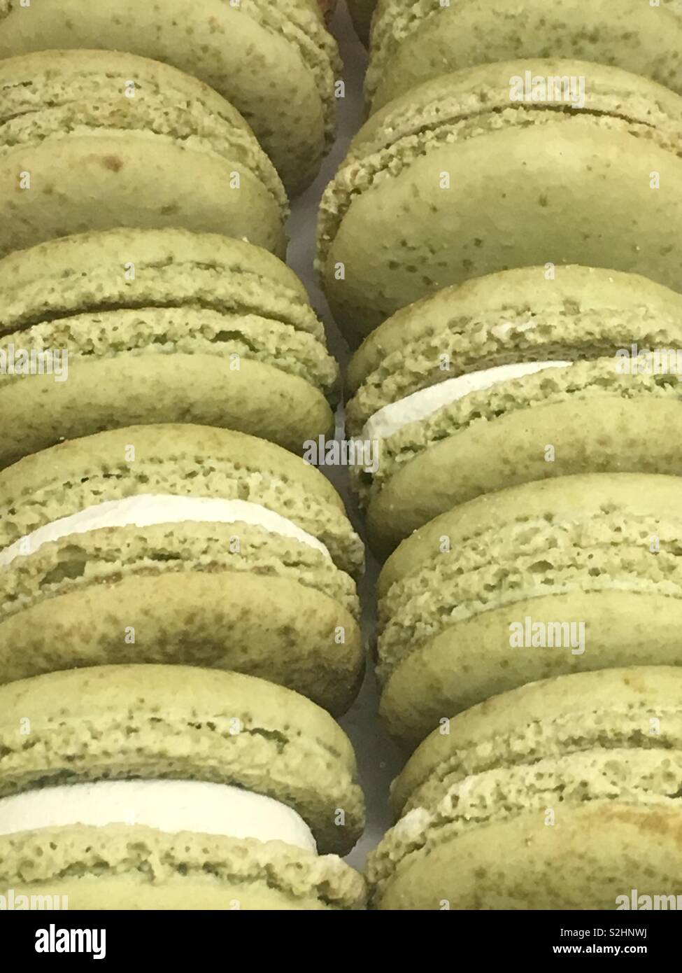 Deliziosa verde verde francese macaron i biscotti con una glassa bianca il riempimento come gustose prelibatezze e deliziosi dessert. Foto Stock