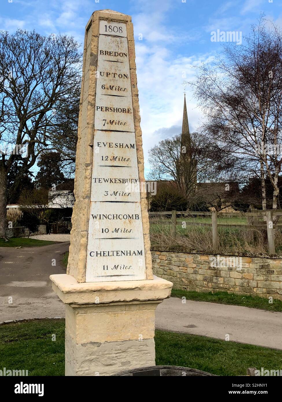 Obelisco eccezionali miglio post, pietra miliare realizzata nel 1808, a Bredon, nella valle di Evesham, specchiata tramite l altissima guglia della chiesa locale. Foto Stock