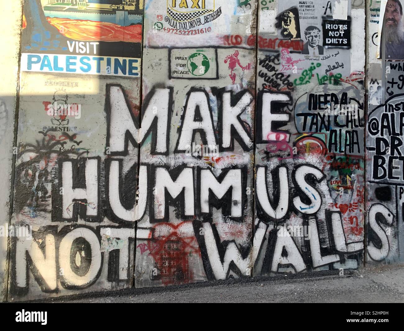 Graffiti arte dipinta sul costruito israeliano parete barriera in Betlemme. Foto Stock