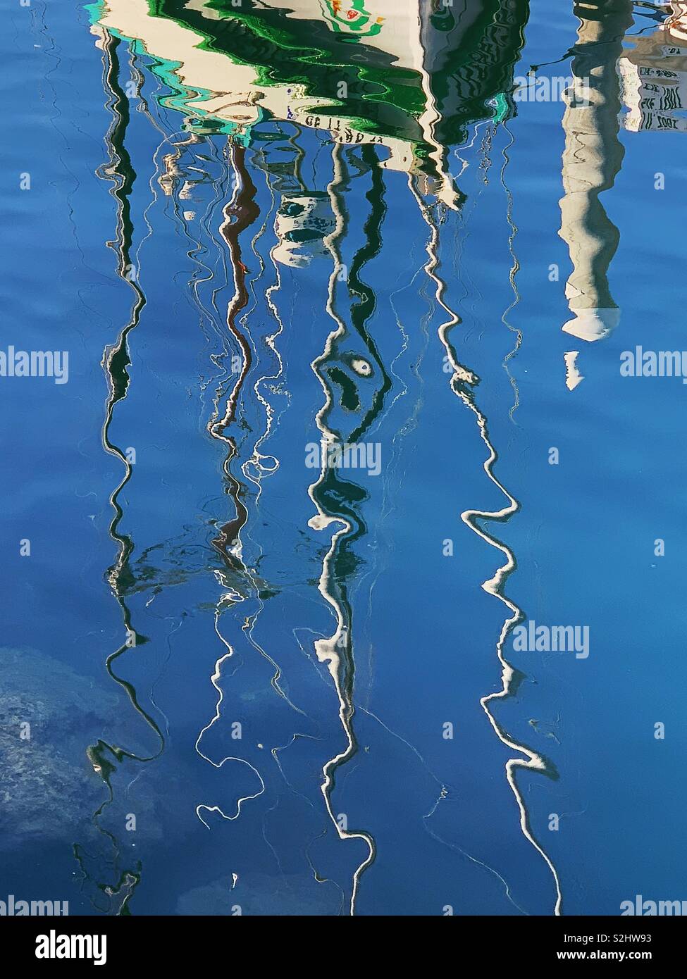 Abstract wiggly linee di colore bianco e verde barca a montanti riflettendo in bagno di acqua blu di Santa Barbara porto. Autunno 2018 - Immagine stock catturata con smartphone