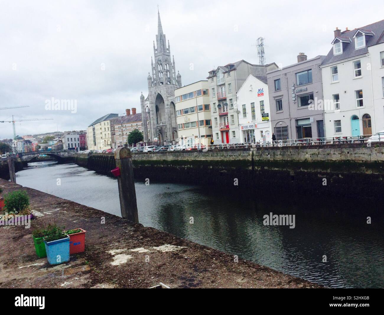 Vista degli edifici della città di Cork e della chiesa sul fiume in Irlanda in un grigio concetto di viaggio e turismo di un giorno autunnale Foto Stock