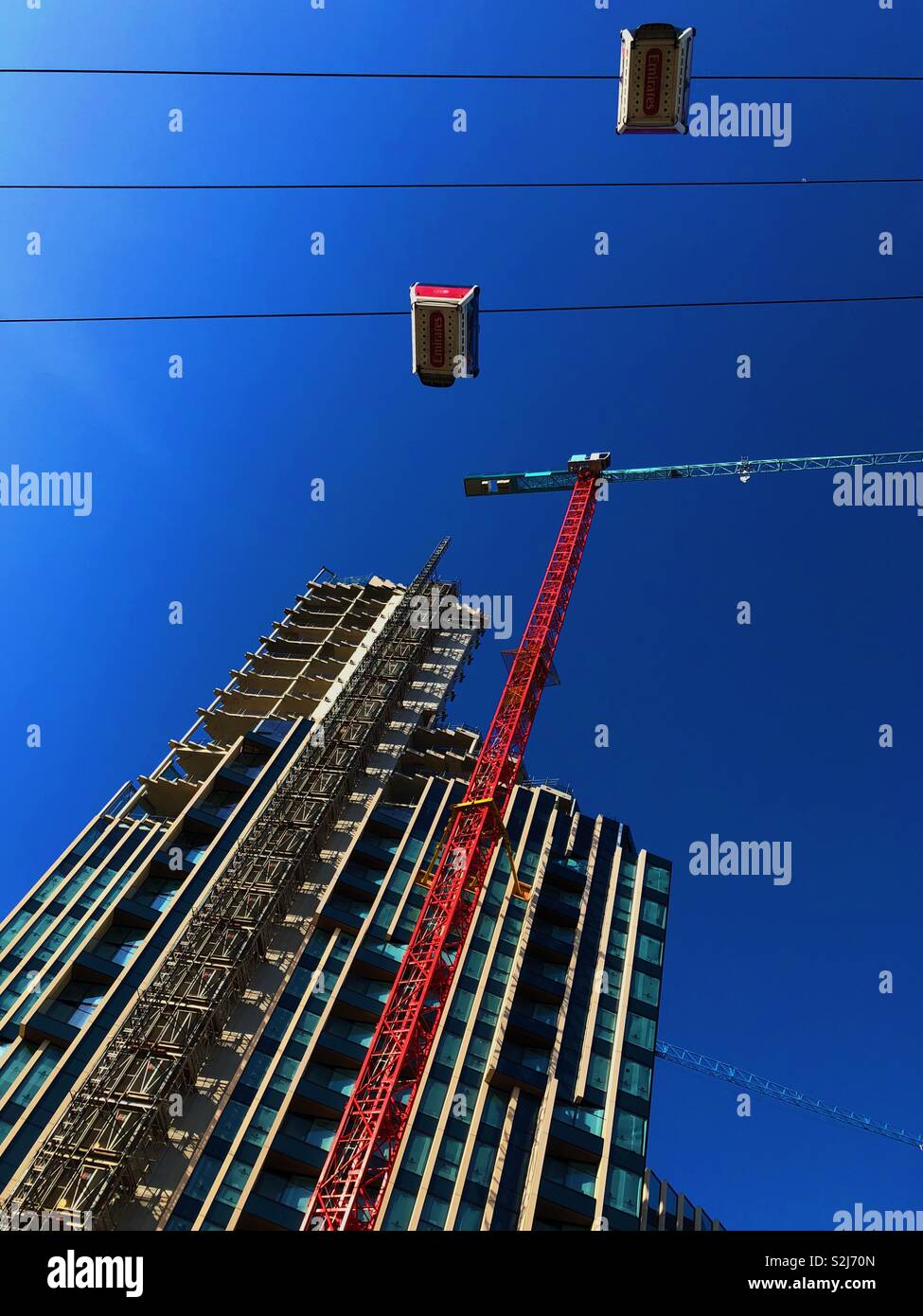 Guardando il nuovo sviluppo di North Greenwich, Londra con Emirates Air Line Funivia contro il cielo blu. - Immagine stock catturata con smartphone